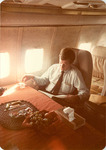 Max Baucus reading on a plane by Creator unknown