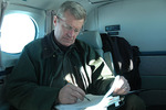 Max Baucus working on airplane by Creator unknown