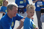 Max Baucus signing a child's shirt at Governors Cup race by Creator unknown