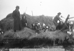 A group of people on top of a pile of hay by Mary Helterline Flynn